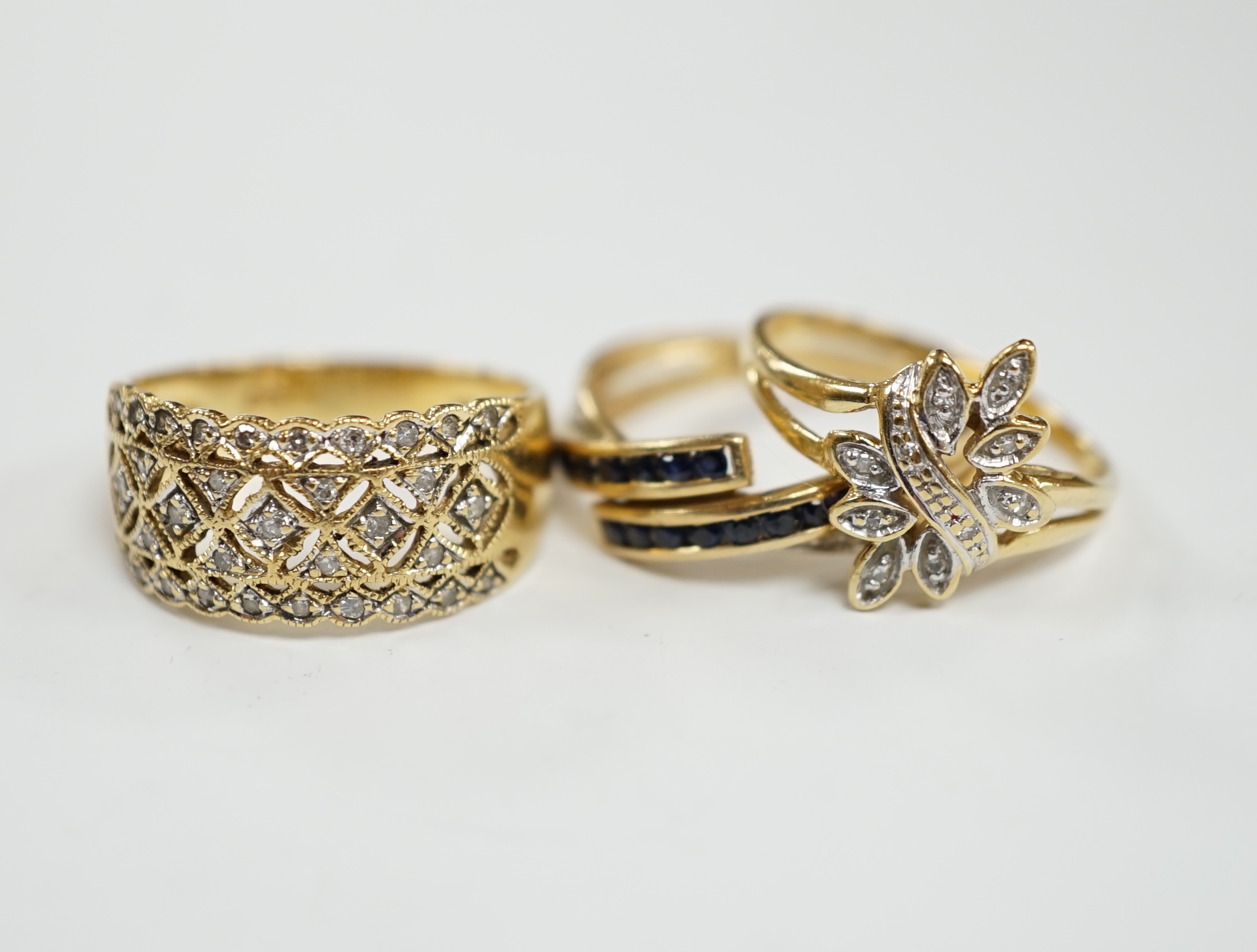 Three assorted modern 18k and gem set rings, including two diamond chip clusters, gross weight 8.2 grams